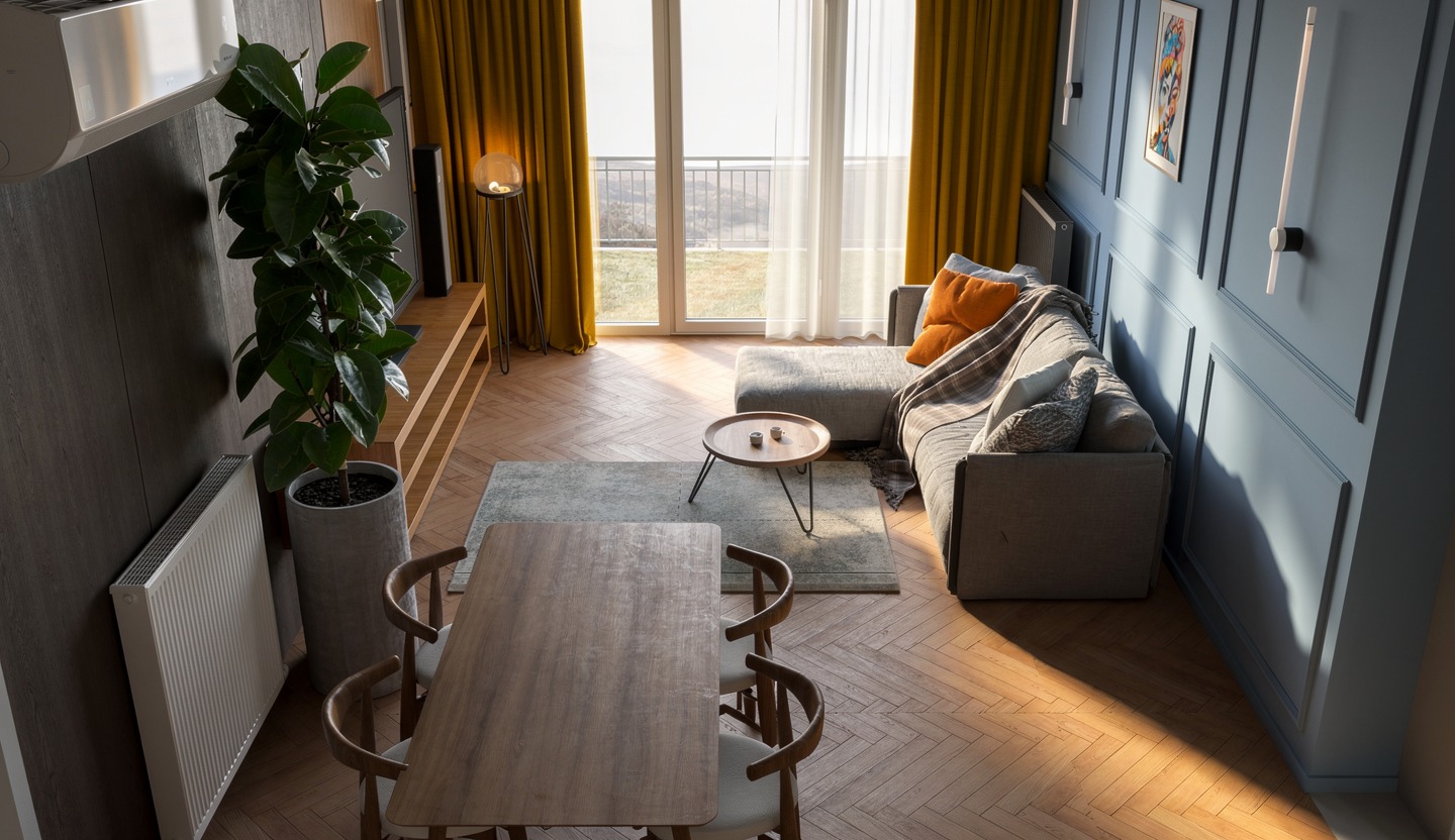 Stylowe wnętrze salonu z parkietem w jodełkę, szarą sofą z poduszkami, drewnianym stołem i zieloną rośliną w betonowej donicy. Naturalne światło przez okno.