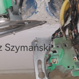 A1ELEKTRO - Uszkodzone gniazdko elektryczne z przypalonymi przewodami, widoczne ślady zwarcia i stopiona izolacja. Niebezpieczna sytuacja wymagająca interwencji elektryka.