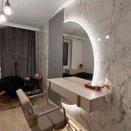 KRDM - Stylowa toaletka z okrągłym lustrem LED i marmurową ścianą. Krzesło z metalową ramą. Elementy dekoracyjne na blacie. Nowoczesny design wnętrza.