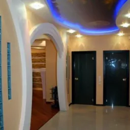 Korytarz z podświetlanym sufitem z motywem nieba, łukowatym wejściem i szklanymi elementami dekoracyjnymi na ścianie.