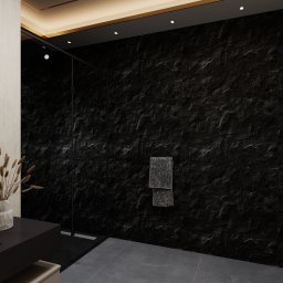 DETAIL SPACE - Nowoczesna łazienka z czarną, teksturowaną ścianą, szklaną kabiną prysznicową i minimalistyczną umywalką. Dekoracyjny wazon z trawami dodaje subtelności.