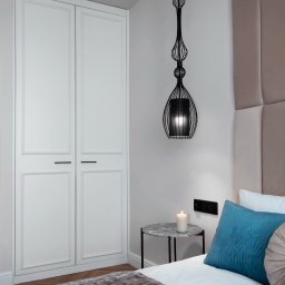 KMK Meble - Elegancka sypialnia z białą szafą wnękową z frezowanymi frontami, designerską lampą wiszącą i łóżkiem z turkusową poduszką. Minimalistyczny stolik nocny.