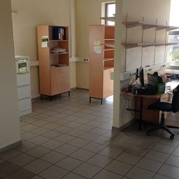 Andrzej Bluszcz - Wnętrze biura przed opróżnianiem: widoczne regały z dokumentami, biurko z komputerem, płytki na podłodze. Przygotowanie do opróżniania.