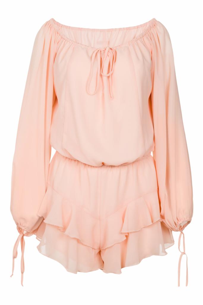 Delikatny, pudrowo-różowy kombinezon z długimi, bufiastymi rękawami, marszczonym dekoltem i falbankami na szortach, prezentowany na białym tle.