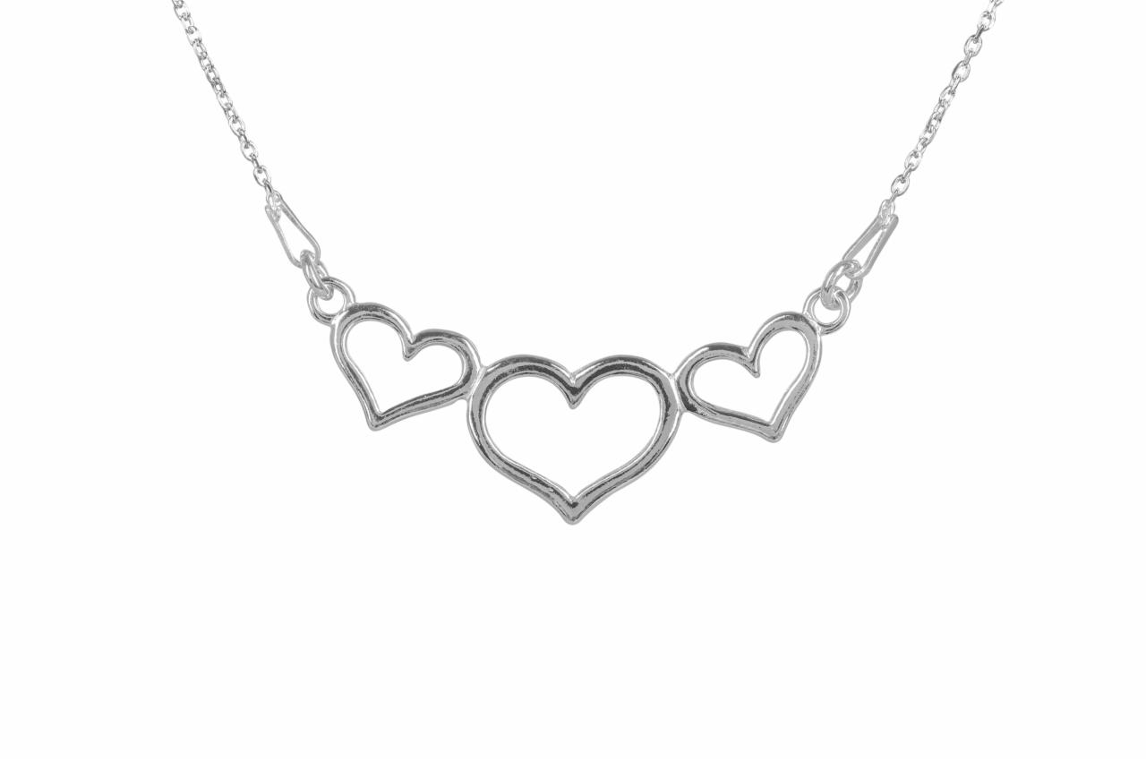 Delikatny, srebrny naszyjnik z trzema sercami o otwartym wzorze, zawieszony na cienkim łańcuszku, prezentowany na białym tle.