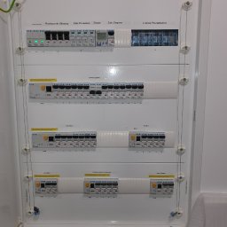 Elek-Info-Sys - Rozdzielnica elektryczna Eaton z zabezpieczeniami, zegarem i listwą rozgałęźną. Widoczne obwody ogólne, kuchnia, biuro, łazienka i kotłownia. Plomba gwarancyjna.