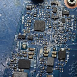 LunarTech Serwis Michał Bojarski - Serwis komputerowy Zielona Góra - Szczegółowe ujęcie płyty głównej laptopa z widocznymi elementami elektronicznymi, układami scalonymi i ścieżkami. Precyzyjna naprawa elektroniki w serwisie komputerowym.