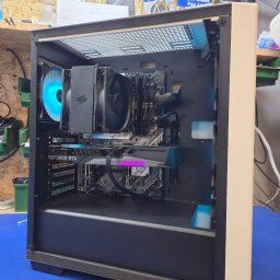 LunarTech Serwis Michał Bojarski - Serwis komputerowy Zielona Góra - Złożony komputer gamingowy z kartą GeForce RTX w obudowie z podświetlanym wentylatorem, widoczna płyta główna ASUS i pamięć G.SKILL, na niebieskim blacie.