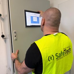 SafeTech Marian Hoppe Sp. z o.o. - Pracownik SafeTech w kamizelce, kalibruje detektor gazu Dräger. Widoczny panel sterowania z ekranem. Usługi detekcji gazów: dobór, sprzedaż, kalibracja, serwis.