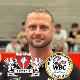 BartDrwal - Portret mężczyzny z logotypami Nak Muay Szczecin i WBC Muaythai, sugerujący trenera sportów walki w tle ringu.