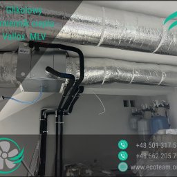 Eco team Łukasz Kulaszewski - Instalacja glikolowego wymiennika ciepła Vallox MLV z izolowanymi rurami, widoczna w pomieszczeniu technicznym. Elementy instalacji wentylacyjnej z folią aluminiową.