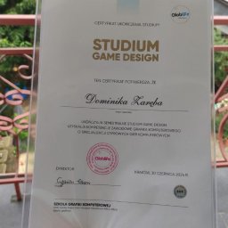 DeKOI Dominika Zadęba - Certyfikat ukończenia studium Game Design, wydany w Krakowie 30 czerwca 2024 roku, trzymany w dłoni na tle zieleni. Dokument potwierdza kompetencje grafika komputerowego.