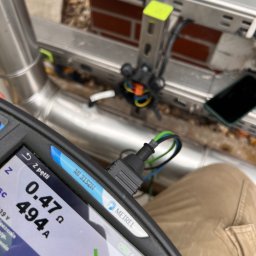 Sinus Energy - Miernik Metrel pokazuje wynik 0.47 Ω i 494 A podczas pomiaru pętli zwarcia instalacji elektrycznej. Widoczne przewody, puszka i fragment instalacji.