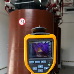 Sinus Energy - Termowizja transformatora energetycznego z użyciem kamery Fluke, widoczne wskazania temperatury na ekranie urządzenia. Diagnostyka instalacji elektrycznej.