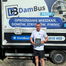 DB DamBus - Mężczyzna prezentuje wyróżnienie na tle busa z hasłem 'Opróżnianie mieszkań, domów, strychów, piwnic' i zdjęciami stanu 'przed' opróżnianiem.
