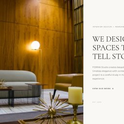 Tim Mach - Ekskluzywne wnętrze z drewnianą ścianą, szarą sofą i złotymi dekoracjami. Lampa podłogowa oświetla przestrzeń. Widoczny napis 'We design spaces that tell stories'.