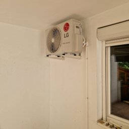 Vortex-montujemy komfort - Biała jednostka klimatyzacji LG Dual Inverter zamontowana na ścianie w pomieszczeniu z oknem i narzędziami na parapecie. Widoczne rury instalacyjne.