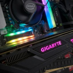 SaganIT - Wnętrze komputera stacjonarnego z podświetlaną kartą graficzną Gigabyte, procesorem Intel i pamięcią RAM XPG, ukazane z bliska pod kątem.