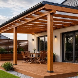 Luk -Stol - Nowoczesna drewniana pergola z przezroczystym dachem i drewnianym tarasem, wyposażona w meble ogrodowe, przylegająca do jasnego domu z dużymi przeszkleniami.