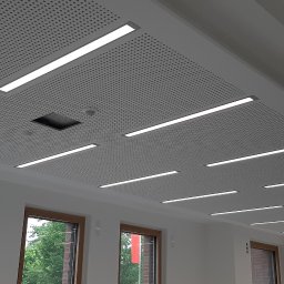 AJ trockenbau - Sufit podwieszany z perforowanej płyty z wbudowanym oświetleniem liniowym. Widoczne okna z drewnianą ramą i fragment kolumny. Detal wykończenia wnętrza.