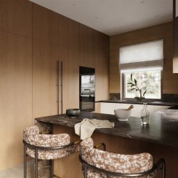 AM design Anna Mrugała - Nowoczesna kuchnia z drewnianymi szafkami, marmurowym blatem i designerskimi krzesłami barowymi. Minimalistyczny wystrój z rośliną w wazonie i oknem z widokiem na zieleń.