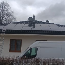 WattProPoland - Panele słoneczne na dachu domu jednorodzinnego z drabina opartą o ścianę i samochodem dostawczym w tle, pochmurny dzień.