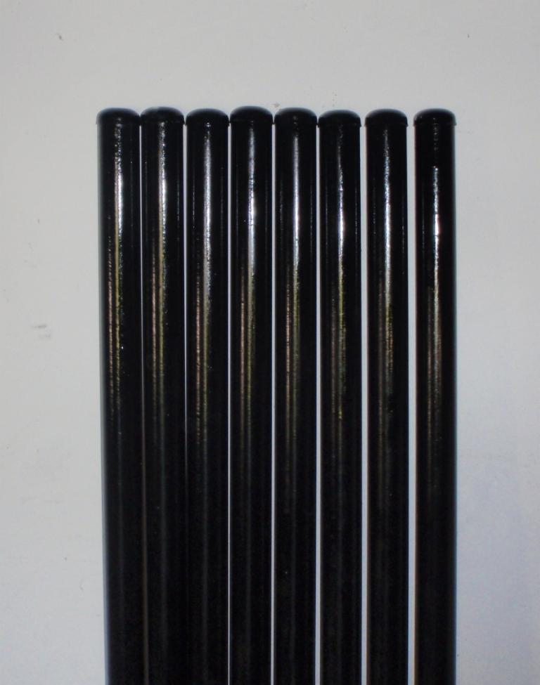 Rząd pomalowanych na czarno słupków ogrodzeniowych o średnicy FI 42 lub FI 48, ustawionych pionowo na białym tle.