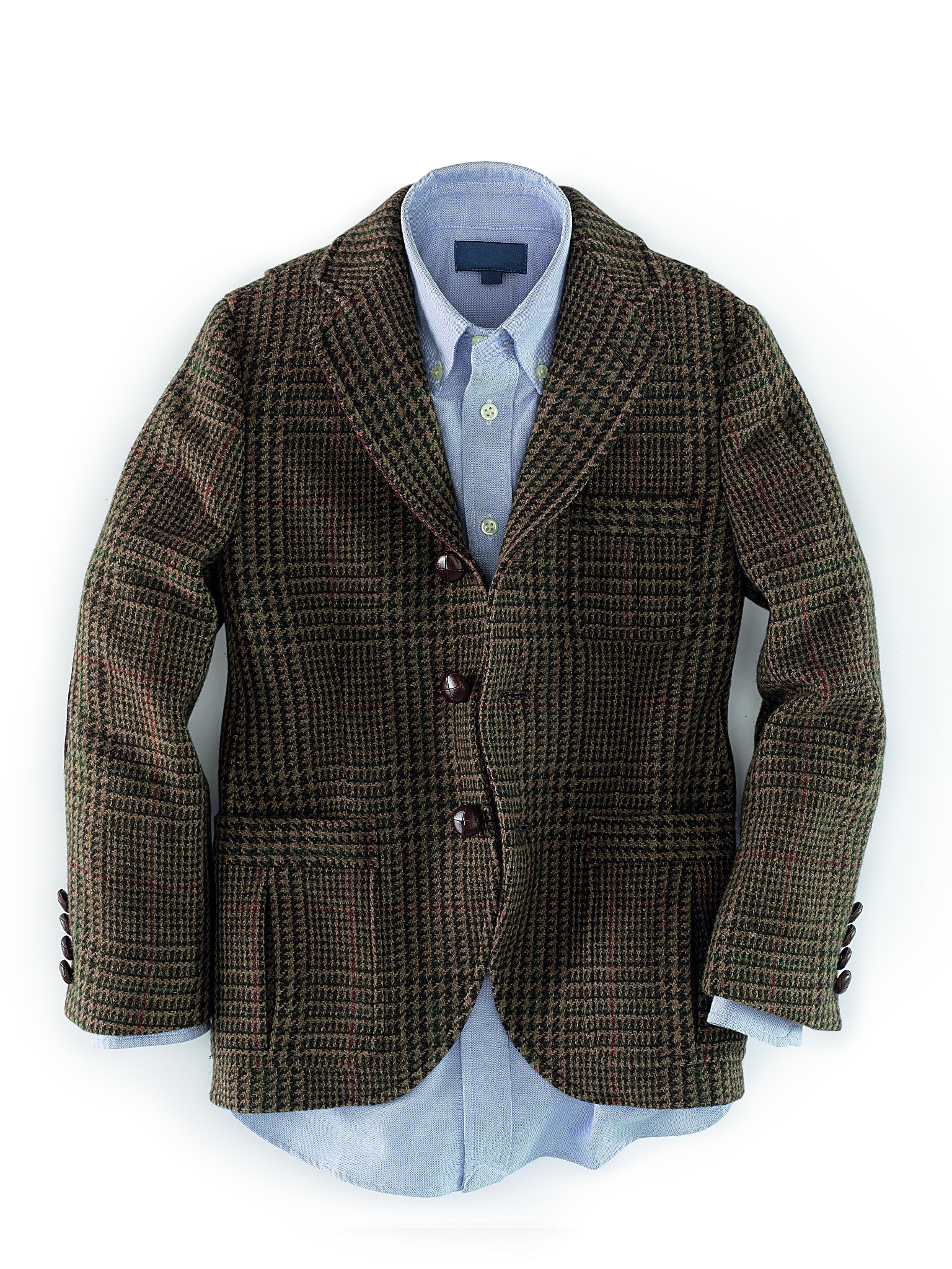 Męska tweedowa marynarka w brązowo-zieloną kratę z trzema guzikami, założona na jasnoniebieską koszulę, leżąca na białym tle.
