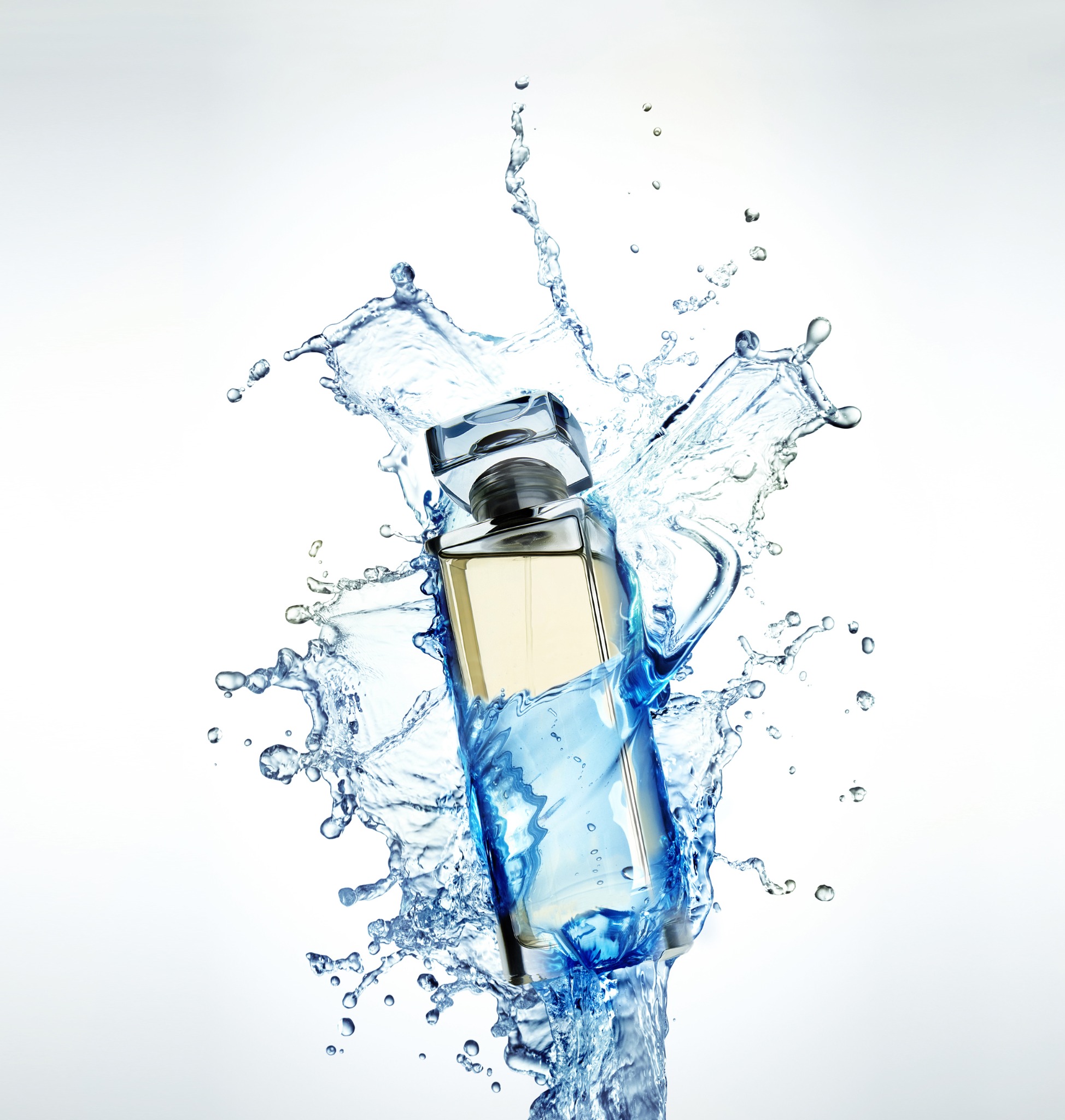 Elegancki flakon perfum otoczony dynamicznymi rozpryskami wody na białym tle, ukazujący świeżość i luksus.