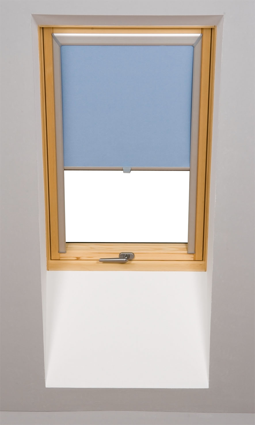 Okno dachowe z częściowo opuszczoną, błękitną roletą tekstylną, drewniana rama okienna, widoczny metalowy uchwyt okna.