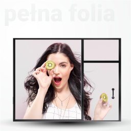 Kiwi Gifts Drukarnia Reklama - Kreatywna prezentacja folii okiennej z młodą kobietą trzymającą kiwi przed okiem, imitującą filtr, na tle okna pokrytego folią.