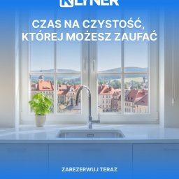 Klyner - Biała kuchnia z widokiem na miasto przez okno. Bateria kuchenna i zlew na pierwszym planie. Promocja firmy sprzątającej Klyner z hasłem o zaufanej czystości.