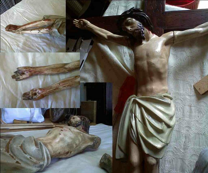 Fragmenty rzeźby Chrystusa na krzyżu w trakcie renowacji: oddzielone ręce, noga i korpus leżą na białym materiale, obok widać krzyż z przymocowanym korpusem.