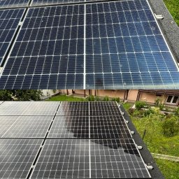 EcoPure Cleaning Solutions - Panele fotowoltaiczne na dachu: górna część brudna, pokryta osadem, dolna część czysta i mokra po myciu, lśniąca w słońcu. W tle zieleń.