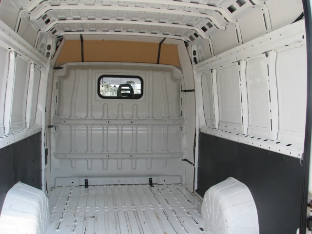 Pusta, biała przestrzeń ładunkowa furgonetki, widok z tyłu, z częściowo zamontowaną izolacją ścian.