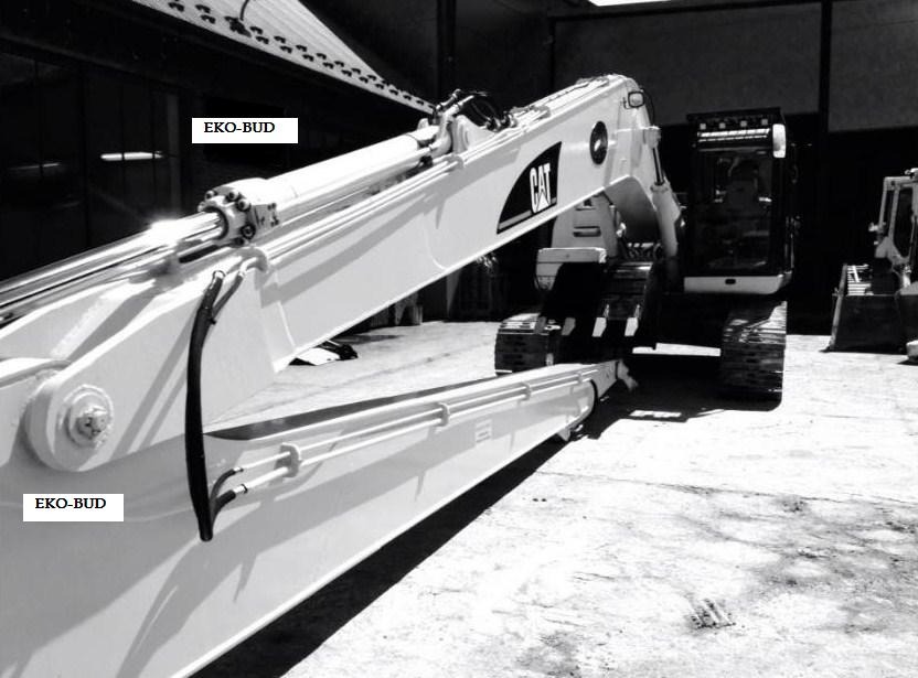 Czarno-białe zdjęcie ramienia i kabiny koparki marki CAT w hali, z widocznym logo firmy EKO-BUD na ramieniu.