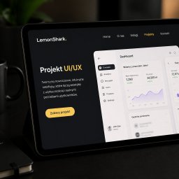 LemonShark. - Tablet z otwartym projektem UI/UX firmy LemonShark, pokazujący nowoczesny panel administracyjny z wykresami i statystykami. Obok firmowy kubek i notes.