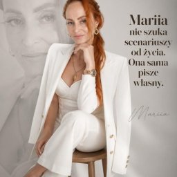 KRAJOWE CENTRUM POMOCY AZYL SPÓŁKA Z OGRANICZONĄ ODPOWIEDZIALNOŚCIĄ - Kobieta z rudymi włosami w białym garniturze i złotą biżuterią siedzi na drewnianym stołku, z ręką na podbródku. W tle jej półprzezroczysty wizerunek i motywacyjny tekst.