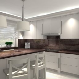 Befart Beata Nowacka - Jasna kuchnia z ciemnym blatem, białymi szafkami i dwoma białymi hokerami z oparciami, z widokiem na zewnątrz przez okno z firankami.