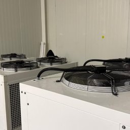 BRG units - Cztery białe, przemysłowe jednostki z czarnymi wentylatorami na górze, połączone przewodami, stojące w rzędzie przy białej, panelowej ścianie.