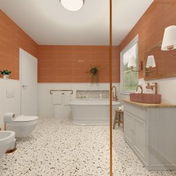 Ronika Design - Nowoczesna łazienka z wolnostojącą wanną, terakotowymi płytkami na ścianach i podłogą lastryko. Miedziane baterie, biała szafka pod umywalkę i rośliny tworzą ciepłe wnętrze.