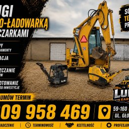 Ludwik Earthworks - Żółta koparko-ładowarka CAT i dwie zagęszczarki na placu z kruszywem przed starym budynkiem, pod pochmurnym niebem. Sprzęt do prac ziemnych.