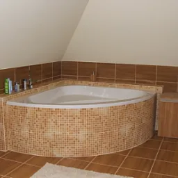 Narożna wanna obłożona mozaiką w odcieniach brązu w łazience na poddaszu, z brązowymi płytkami na ścianach i podłodze, uzupełniona o drewniane szafki.