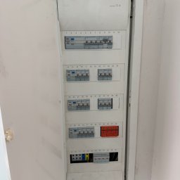 M.S Elektro - Mikołaj Smolik - Otwarta, wbudowana rozdzielnica elektryczna z rzędami bezpieczników Hager i pomarańczowymi ochronnikami przepięć, ukazująca precyzyjne okablowanie w Zielonej Górze.