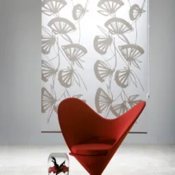 Wnętrze z dekoracyjną roletą z motywem roślinnym, czerwonym krzesłem i wazonem z kwiatami.