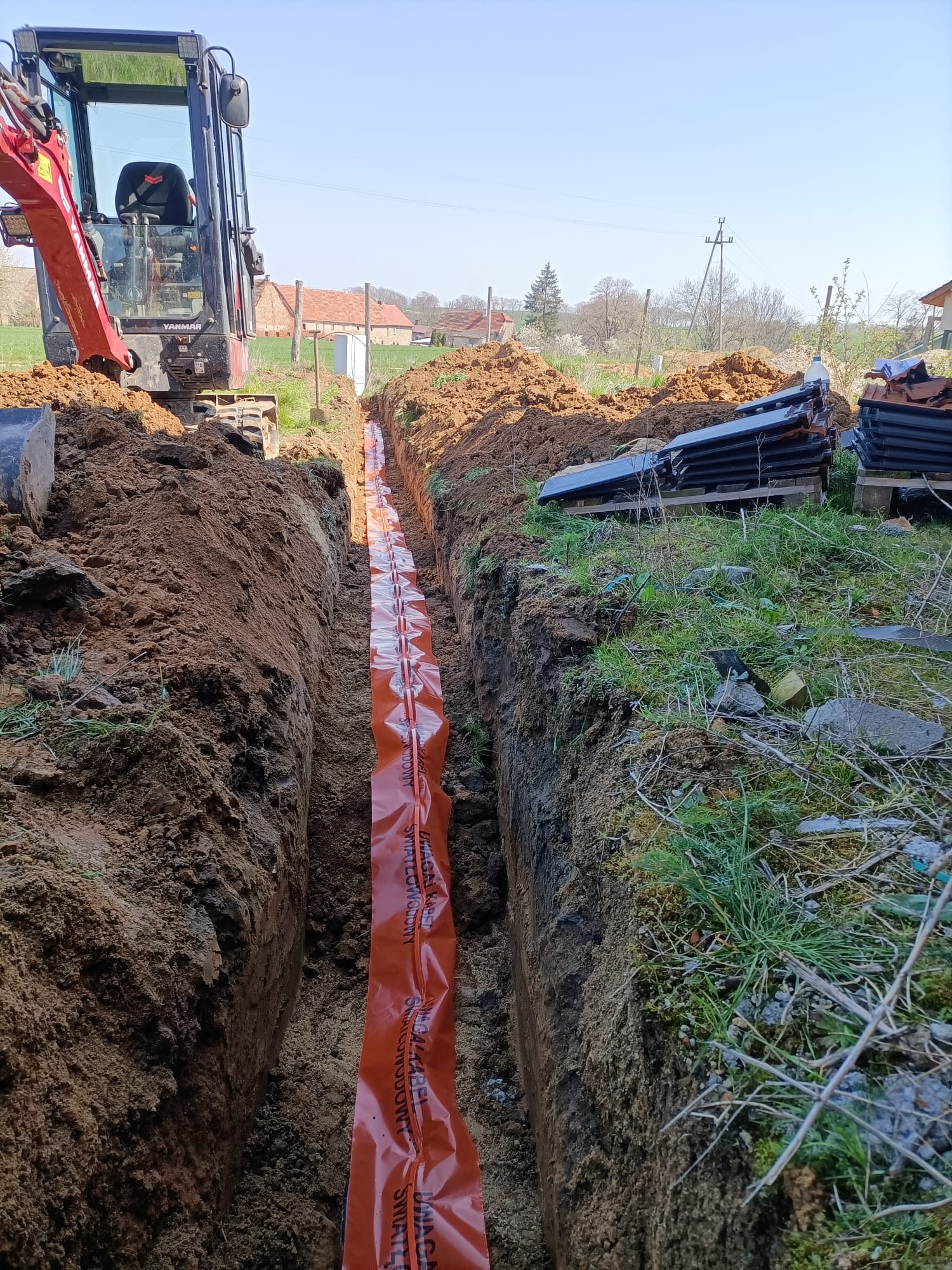 Wykop pod instalację elektryczną (podsypka, folia ostrzegawcza, zagęszczenie wykopu) zgodnie ze sztuką.