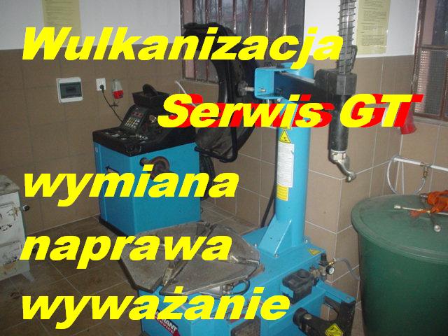Niebieskie urządzenia do wulkanizacji i wyważania opon w warsztacie, z widocznym napisem 'Serwis GT' i żółtymi napisami 'Wulkanizacja', 'Wymiana', 'Naprawa', 'Wyważanie' na zdjęciu.
