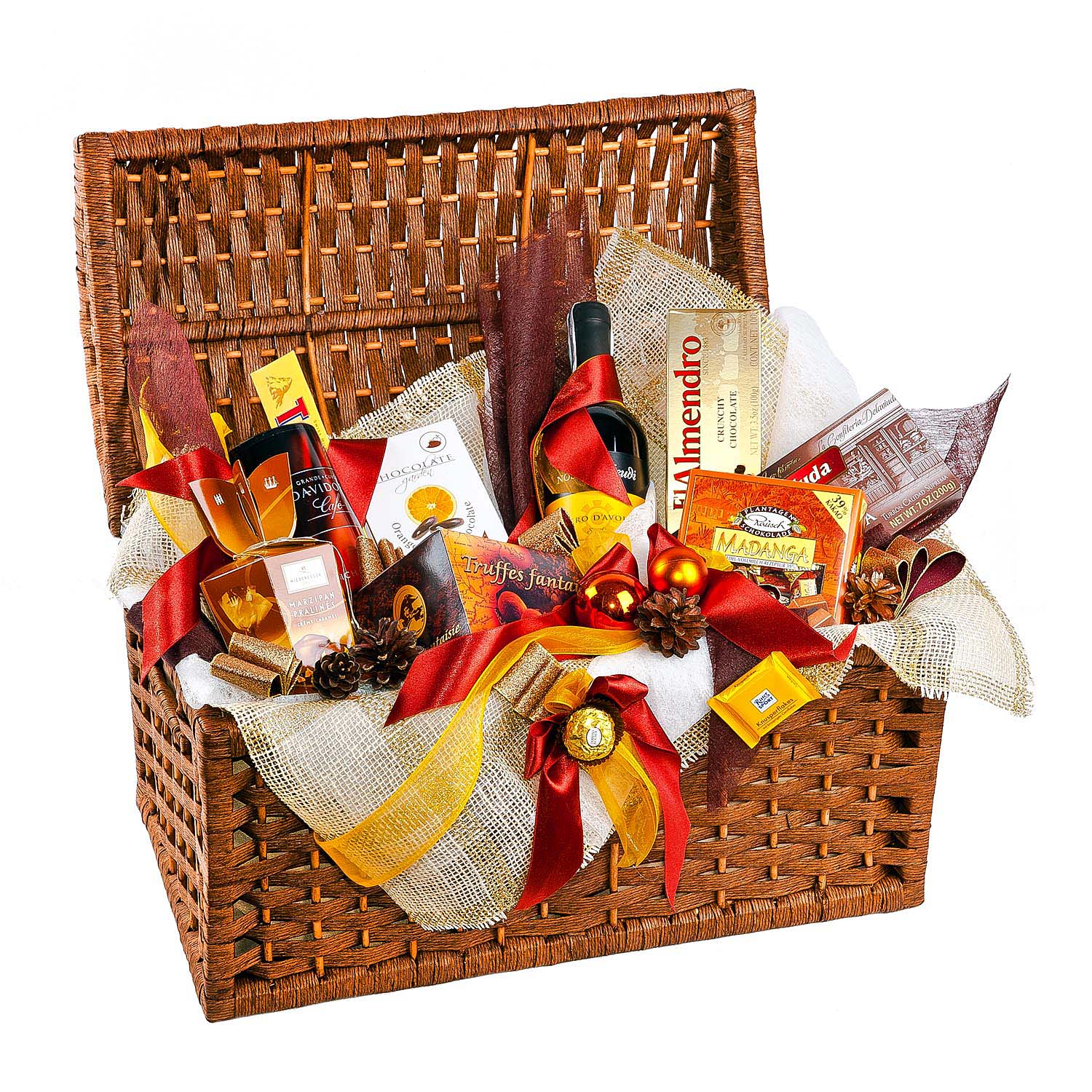 Otwarty wiklinowy kosz wypełniony luksusowymi słodyczami, butelką wina obwiązaną czerwoną wstążką, dekoracjami świątecznymi i materiałami ozdobnymi, całość utrzymana w ciepłej, świątecznej...