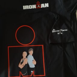 Hifilon Drukarnia DTF - Czarna koszulka JHK 190g z białym logo IRON MAN, dużą grafiką dwóch stylizowanych postaci sportowców w czerwonej ramce oraz napisem 'SKRZYNKOWSKI TEAM' na rękawie.