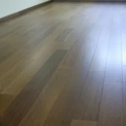 Lakierowana podłoga z desek Merbau, widoczne subtelne refleksy światła i listwa przypodłogowa przy ścianie.